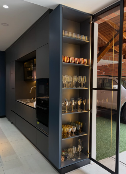 Cocina negra a medida con vitrina iluminada y carpintería arquitectónica de Proyecto EME